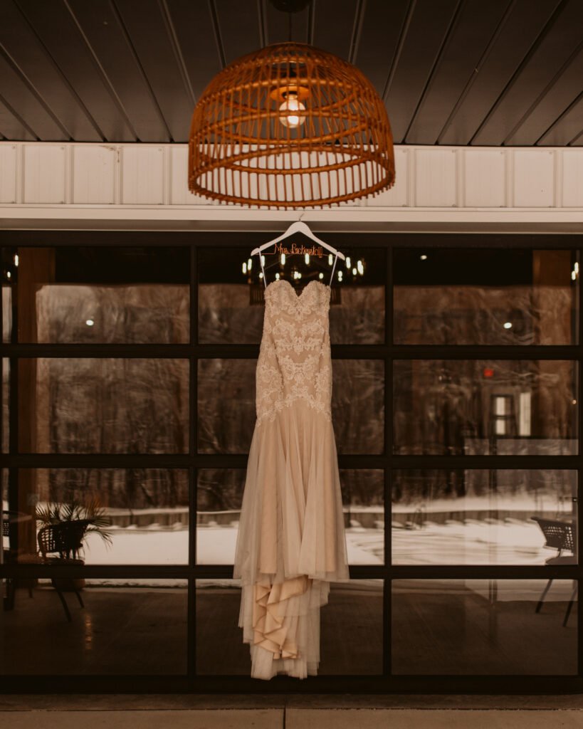White bridal dress hung from a hanger at Meadville, PA wedding venue The Harper. 